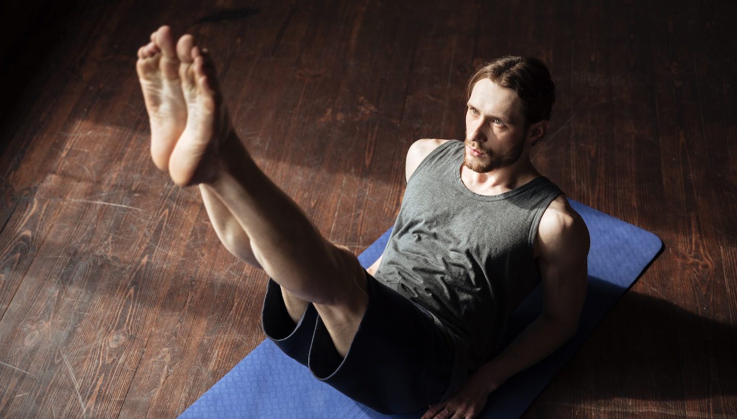 αθλητής ασκείται στη yoga κάνοντας κοιλιακούς